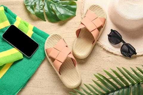 Summer beach vacation essentials flat lay with smartphone, sandals, hat, sung Stock Photos