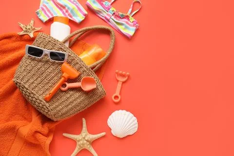 Summer beach vacation essentials with straw bag, swimsuit, sunscreen, and san Stock Photos