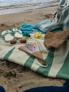 Summer beach vacation essentials on striped towel Фото