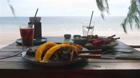 Summer beachside dining setup with iced drinks and grilled food, Видео 285169655