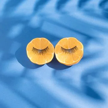 Summer beauty flat lay created with yellow lemon slices with female lashes an Stock Photos