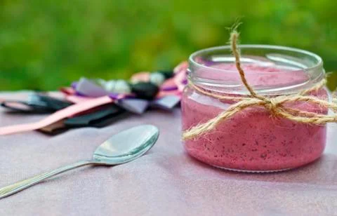 Summer berry dessert in a jar on a light background. Side view Stock Photos