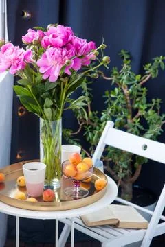 Summer breakfast on balcony. Two cups of drink, bouquet of pink peonies, old Stock Photos