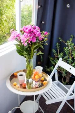 Summer breakfast on balcony. Two cups of drink, bouquet of pink peonies, old Stock Photos