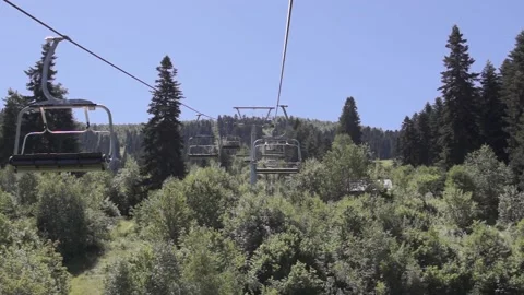 Summer cable car over the forest leading to the mountains Stock Footage 94260122