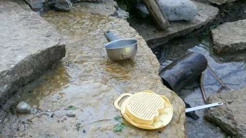 Summer camp for children with kitchen cookware in creek for creative playtime Stock Footage 321572470