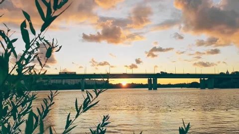 Summer, city, sunset river. sun sets horizon. Silhouette of a transport bridge Stock Footage 163553783