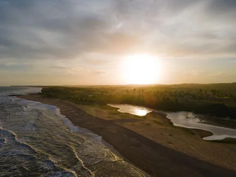 Summer cloudy sunset reflecting on the waves of Imbassai Beach, Bahia, Brazil. Foto stock