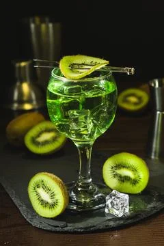 Summer cold drink and beverages. Alcohol coctail with kiwi and ice in wine glass Stock Photos