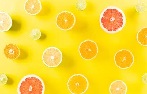 Summer composition made from oranges, lemon or lime on pastel yellow backgrou Stock Photos