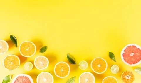 Summer composition made from oranges, lemon or lime on pastel yellow backgrou Stock Photos