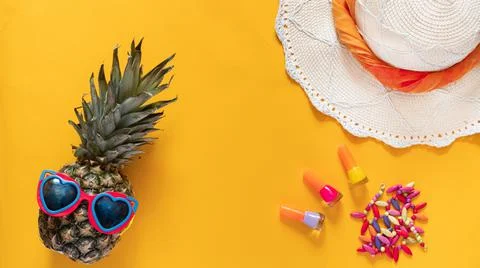 Summer composition. Pineapple in sunglasses, hat, beads and nail polishes on a Stock Photos
