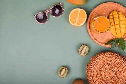 Summer composition. Sunglasses mango, orange, kiwi on green background. Flat  Stock Photos