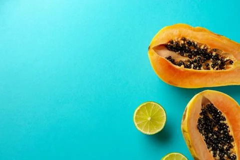 Summer composition. Tropical lime and papaya fruit cut in half lie on a blue Stock Photos