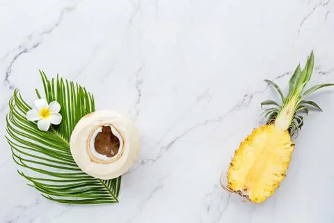 Summer composition. Tropical palm leaf, coconut, pineapple on white marble ba Stock Photos