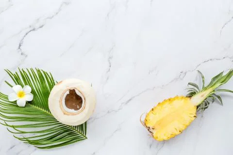 Summer composition. Tropical palm leaf, coconut, pineapple on white marble ba Stock Photos