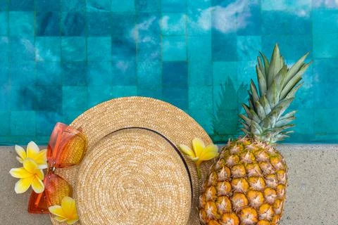 Summer concept. Hat, glasses, pineapple, flowers by the pool. Foto stock