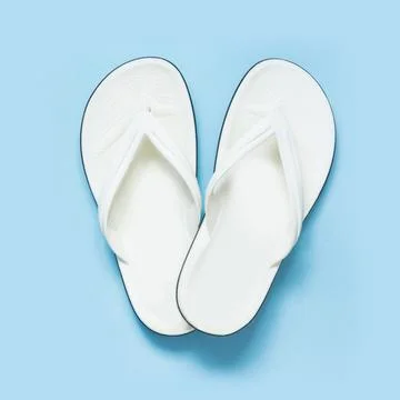Summer concept. White flip flops over blue background. Top view. Fotos Stock