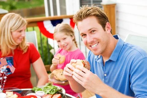 Summer: dad eating a hamburger Stock Photos