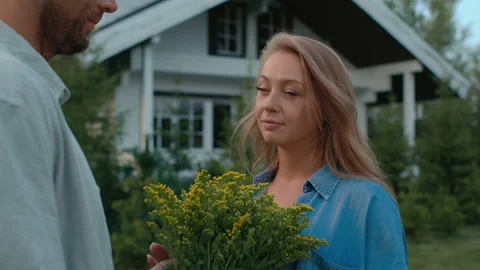 Summer date of happy couple at front yard near cottage. Family spending romantic Stock Footage 199482411