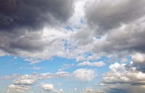 Summer dramatic clouds fly across a bright blue sky. Stock Photos