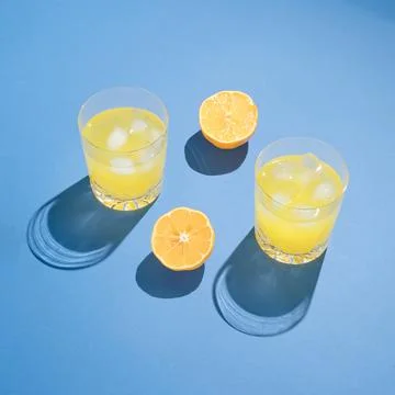 Summer drink composition made of lemon slices and cocktail glasses on blue ba Foto stock