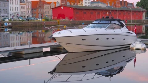 Summer evening view of the Old Town pier and boat with reflection in Lubeck Видео 78057668