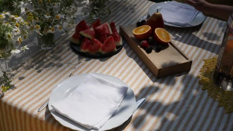 Summer festive table setting in yellow palette with field daisies and watermelon Stock Footage 278476156