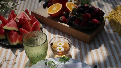 Summer festive table setting in yellow palette with field daisies and watermelon Stock Footage 278476343