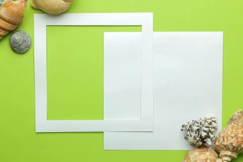 Summer frame. Paper frame for your text and seashells on a bright green backg Stock Photos
