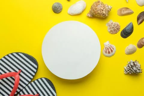 Summer frame. Paper frame for your text, flip flops and seashells on bright y Stock Photos