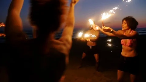 Summer, Freedom, Party: people enjoying with sparklers at night on the beach Stock Footage