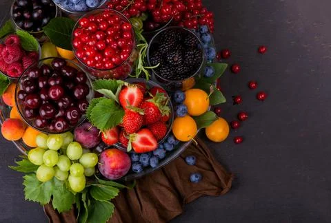 Summer fresh berries of different types on a black background Stock Photos