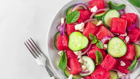 Summer fruit and vegetable salad made of watermelon, cucumber, soft cheese and Stock Footage 239979721