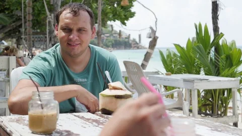 Summer fruit cocktail on the beach. Two friends are drinking cocktails in a cafe Vidéo 127150436