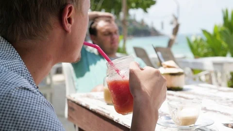 Summer fruit cocktail on the beach. Two friends are drinking cocktails in a cafe Vidéo 127150492