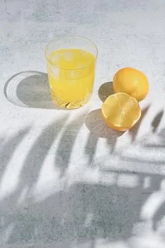Summer fruit composition made of lemon and cocktail glass in the shadow. Mini Stock Photos