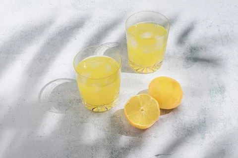 Summer fruit composition made of lemon and cocktail glass in the shadow of pa Foto stock
