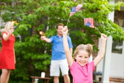Summer: girl in front yard with american flags Stock Photos