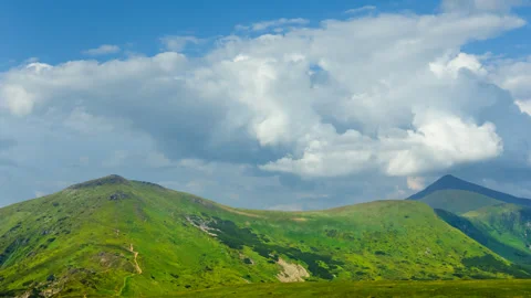 Summer green mountain ridge under a cloudy sky Stock Footage 310656366