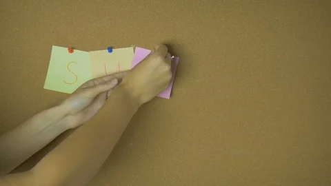 Summer. Hands pining and taking off sticky windy notes on pin board funny Stock Footage 99565354