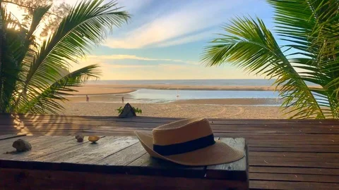 Summer hat sitting on a table with sea view in the background Stock Footage