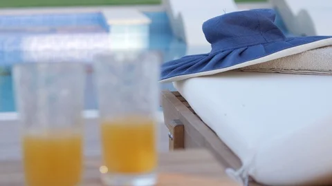 Summer hat on a sunbed by the pool Stock Footage 97014348