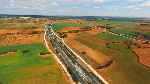 Summer highway surrounded by fields meadows. Nature and traffic road Stock Footage 124465118