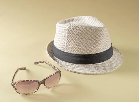 Summer holiday accessories.Straw hat and sunglasses on sepia toned background Stock Photos