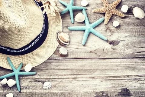 Summer holiday setting with straw hat and seashells Stock Photos