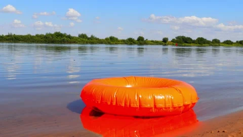Summer. Inflatable orange circle floats on the river Stock Footage 220361313