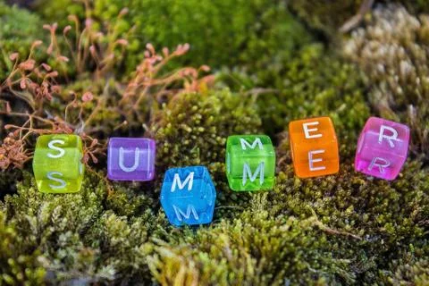 Summer inscription multicolorsquare beads with letters on green moss Stock Photos
