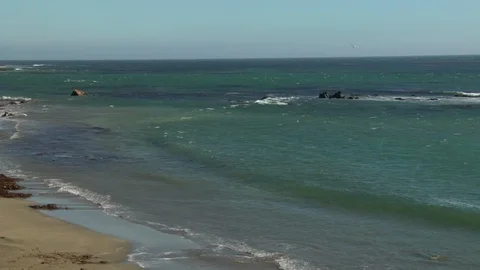 Summer island ocean waves roll in and out with the tide on empty beach Stock Footage 125341277