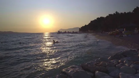 Summer joy, enjoying into the waves on Sunset Stock Footage 168974495